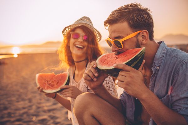 comienodo sandia en una playa